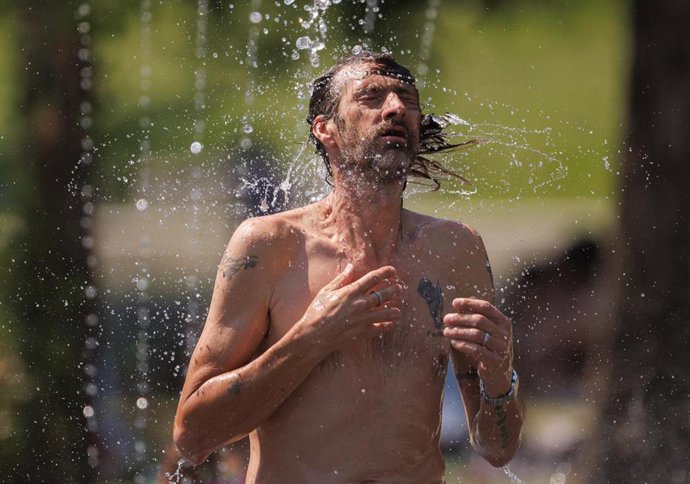 Un chico se refresca ante el fuerte calor
