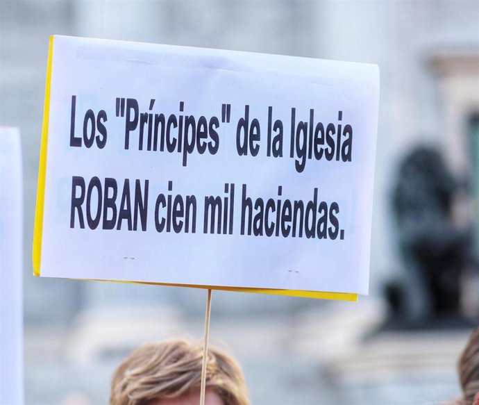 Archivo - Algunas personas protestan frente al Congreso de los Diputados para denunciar los bienes inmatriculados por la Iglesia católica.