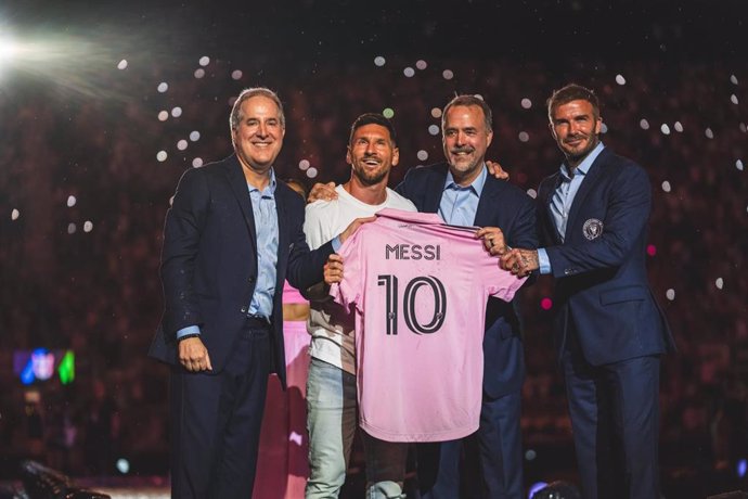 Leo Messi posa con su nueva camiseta del Inter de Miami junto a los dirigentes del club, entre ellos David Beckham, dueños del club.