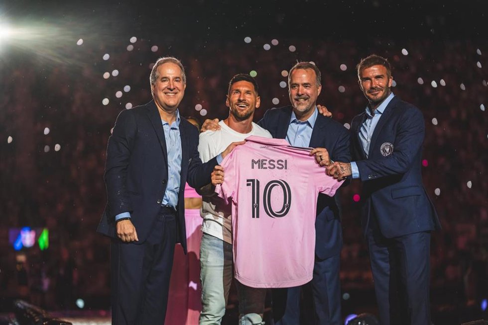 Leo Messi posa con su nueva camiseta del Inter de Miami junto a los dirigentes del club, entre ellos David Beckham, dueños del club.