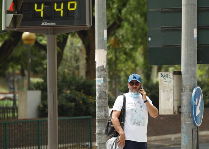 Archivo - Un hombre habla por el móvil junto a un termómetro que marca 44 durante un día de alerta roja por altas temperaturas, a 12 de julio de 2021, en la ciudad de Murcia, Murcia (España).