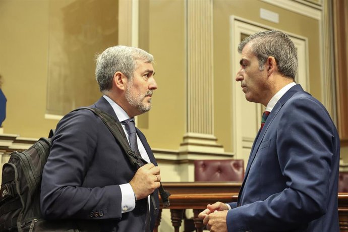 El presidente del Partido Popular (PP) de Canarias, Manuel Domínguez (d), y el nuevo presidente del Gobierno de Canarias, Fernando Clavijo (i), tras la segunda jornada del Pleno del debate de investidura