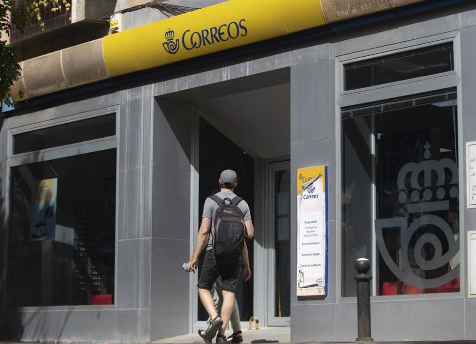Una persona entra en una oficina de correos. A 17 de julio de 2023, en Sevilla (Andalucía, España).