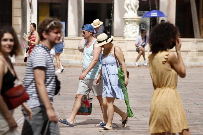 Archivo - Varias personas intentan protegerse del calor. Imagen de archivo.