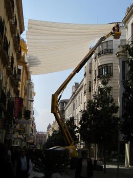 Archivo - Operarios trabajan a gran altura en la colocación de toldos en una calle de Córdoba en una imagen de archivo.