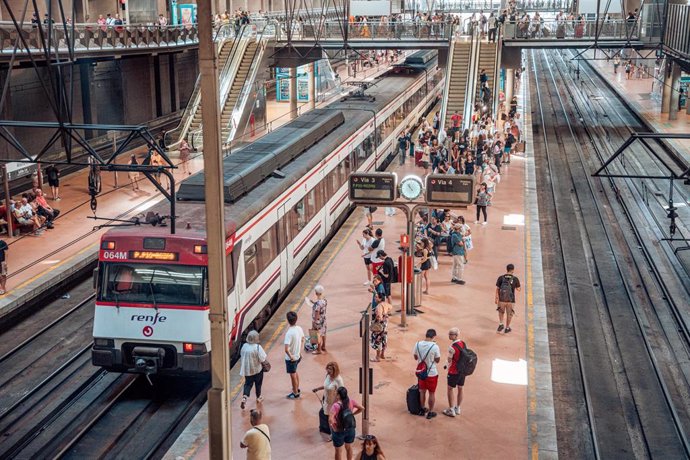 Varias personas en el andén de un tren de cercanías en la estación Almudena Grandes-Atocha.