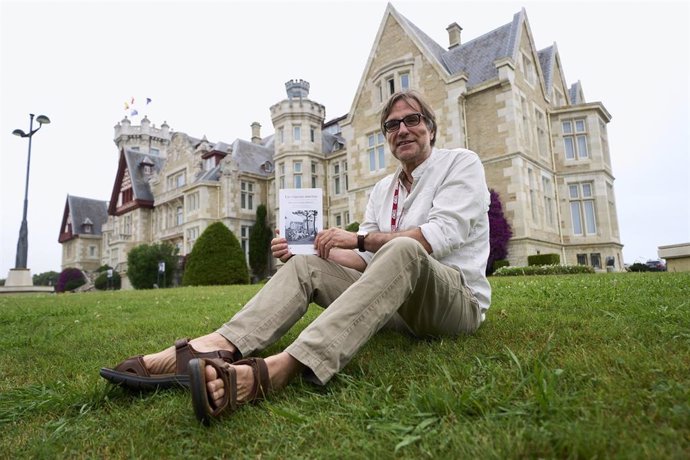 El escritor Francisco López Serrano posa con su novela 'Las vísperas muertas' frente al Palacio de la Magdalena de Santander.