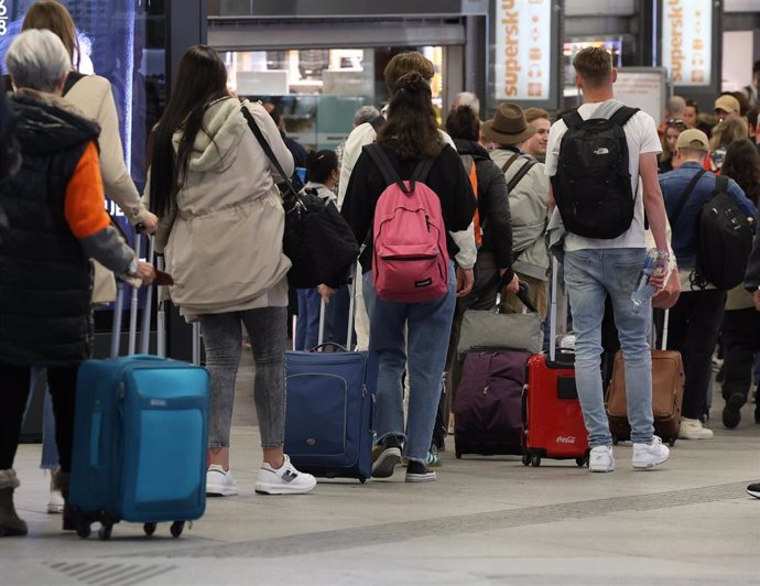 Archivo - Numerosas personas con maletas salen de viaje en la estación Almudena Grandes-Atocha Cercanías donde se inicia la operación de Semana Santa, a 31 de marzo de 2023, en Madrid (España).