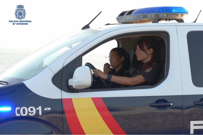 Dos agentes en un furgón de Policía Nacional.