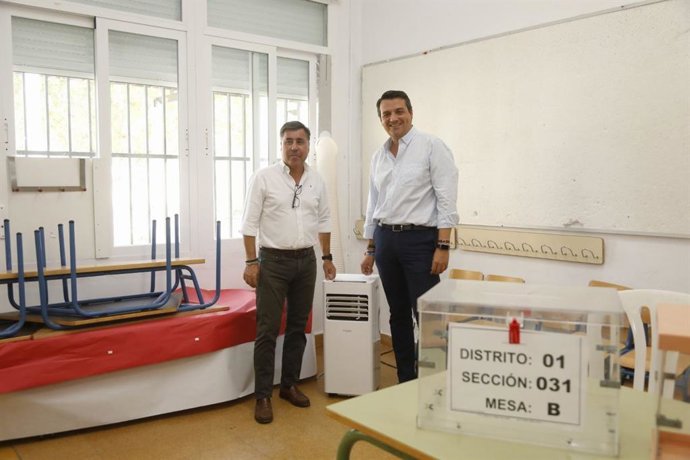 Bellido (dcha.) y Ruiz Madruga, junto a uno de los aparatos de refrigeración en un colegio electoral de Córdoba.