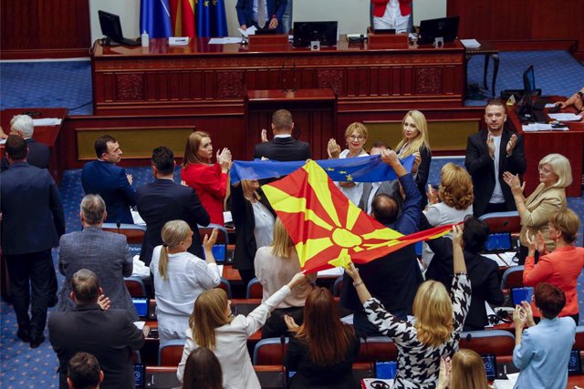 Archivo - Legisladores muestran banderas de Macedonia del Norte y de la UE en el Parlamento en Skopje