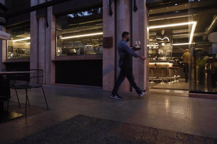 Archivo - Un camarero lleva una bandeja en una cafetería en Palma, Mallorca (España).