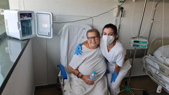 Una paciente y una profesional sanitaria junto a una de las neveras.