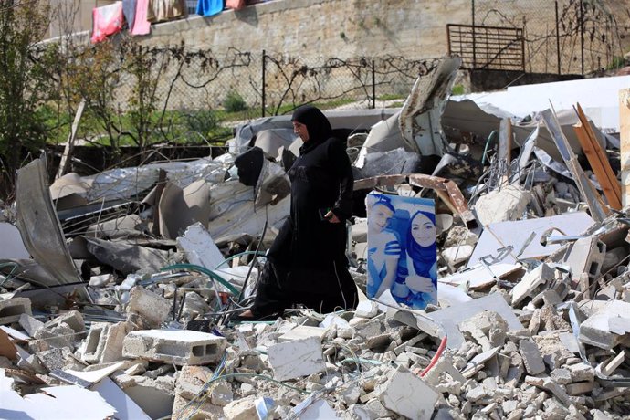 Archivo - Una mujer palestina camina por los restos de un edificio derruido por las autoridades israelíes en Jerusalén