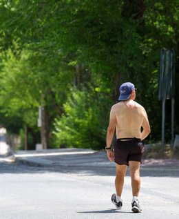 Una persona camina sin camiseta
