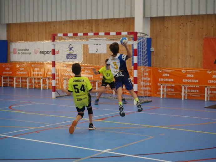 Niños practicando balonmano en un centro deportivo