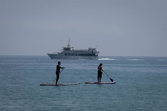 Archivo - Dos personas hacen paddle surf.