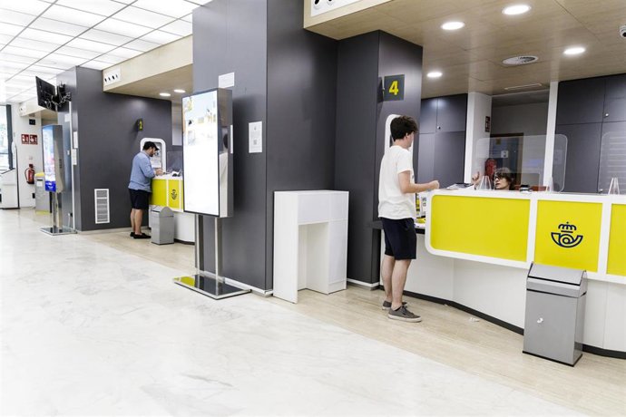 Un joven es atendido en la oficina de Correos de la calle Conde de Peñalver, a 21 de julio de 2023, en Madrid (España). 