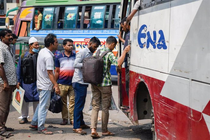 Archivo - Migrantes se suben a un autobús en Bangladesh