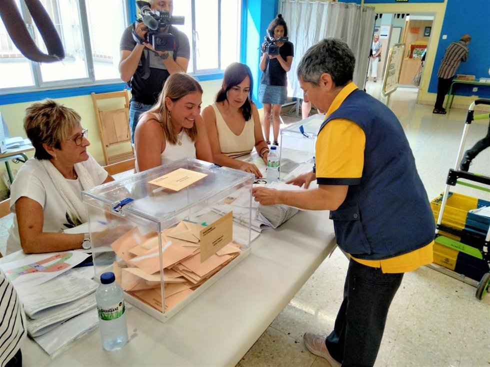 La trabajadora de Correos depositando los votos por correo en una mesa electoral del colegio Los Sauces.