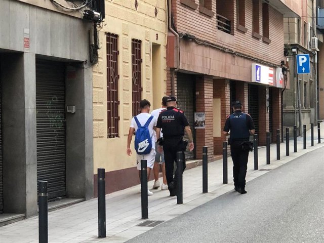 Los jóvenes acompañados por los Mossos tras cogerles los datos