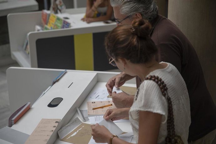 Dos personas votando por correo las elecciones del 23J un día antes de que se acabe el plazo. 