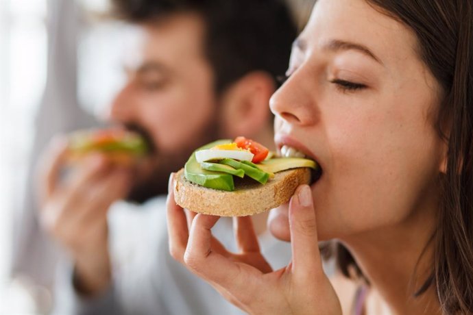 Archivo - Mujer y hombre comiendo.