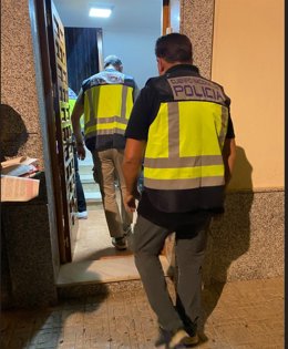 Agentes de la Policía Nacional entran en el piso donde se explotaba a las dos mujeres