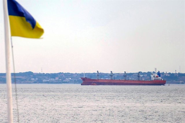 Bandera de Ucrania en el mar Negro junto a un barco cargado de cereales