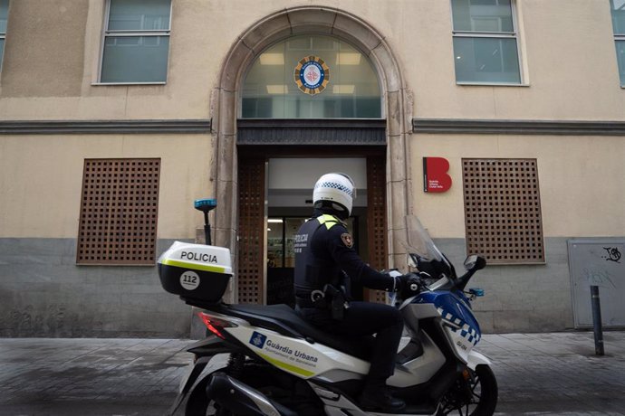 Archivo - Un agente de la Guardia Urbana ante la entrada de la nueva comisaría del Raval de Barcelona.