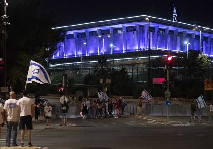 Manifestantes contra la reforma judicial del Gobierno caminan frente al Parlamento israelí, o Knesset, en Jerusalén.