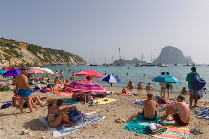 Varias personas en la playa de Cala d'Hort, a 11 de julio de 2023, en Ibiza, Islas Baleares (España). Los datos de la Federación Empresarial Hotelera de las Pitiusas indican que todas las zonas turísticas de la isla de Ibiza registraron grandes caídas d