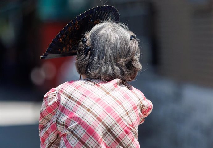 Una mujer mayor se protege del sol con un abanico, a 24 de julio de 2023, en Madrid (España).
