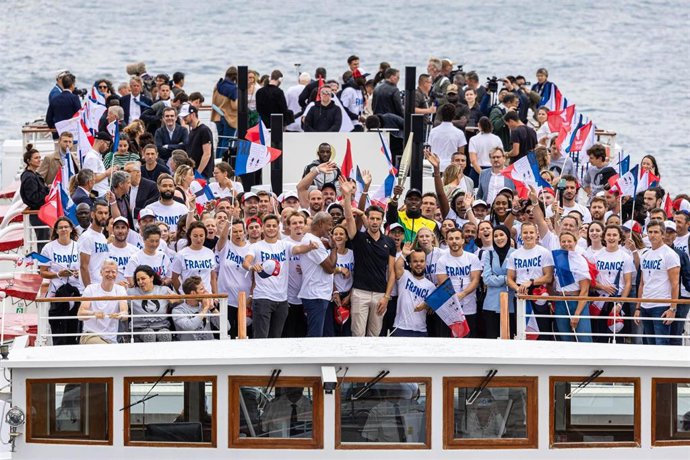 Usain Bolt presenta sobre el río Sena la antorcha de los Juegos de París 2024.