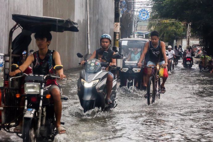 MALABON CITY, July 26, 2023  -- People wade through a water-logged area in Malabon City, the Philippines, on July 26, 2023. The Philippines' national disaster agency on Wednesday said it has so far tallied at least one dead as Typhoon Doksuri continued to