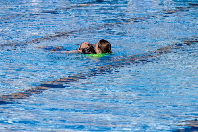 Miembros del SUMMA 112 realizan un simulacro de rescate y reanimación cardiopulmonar (RCP) en caso de ahogamiento, en las Instalaciones Deportivas del Canal de Isabel II, a 25 de julio de 2023, en Madrid (España). Durante el simulacro, a cargo de técnic