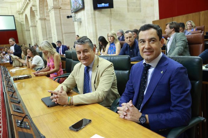 El consejero de la Presidencia, Interior, Diálogo Social y Simplificación Administrativa, Antonio Sanz (i), y el presidente de la Junta de Andalucía, Juanma Moreno (d), en el Pleno del Parlamento andaluz. (Foto de archivo).