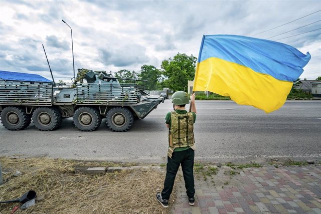 Niño ucraniano ondea la bandera nacional ante el paso de equipos militares de Ucrania hacia Bajmut