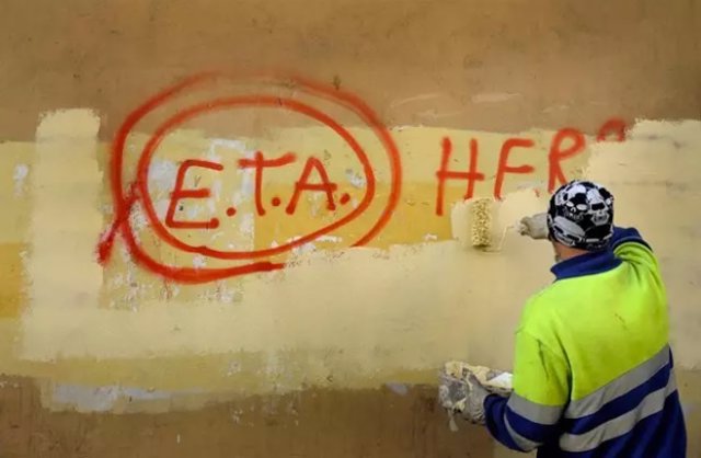 Un hombre borra una pintada de ETA en Guernica, Euskadi.
