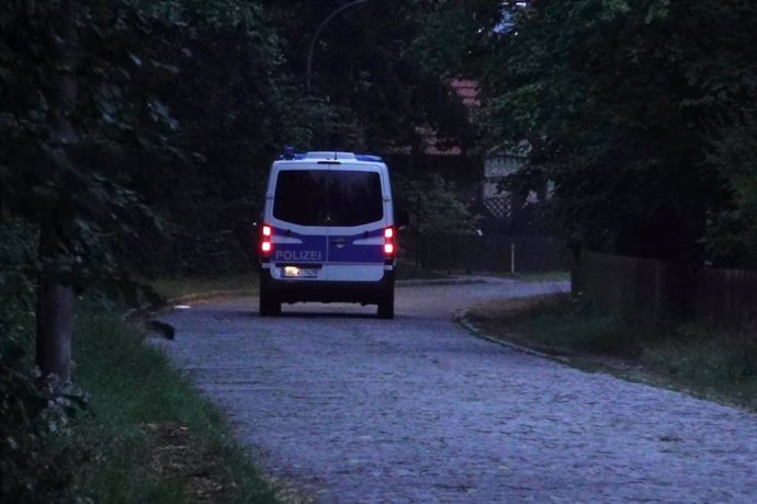 20 July 2023, Brandenburg, Kleinmachnow: A police emergency vehicle drives along a road during a search operation for a dangerous wild animal on the loose in the area of the southern border of Berlin. Berlin police sent out a warning over night that a lar