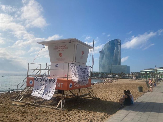 Un punto de vigilancia de los socorristas de Barcelona en la playa de la Barceloneta con pancartas reivindicativas