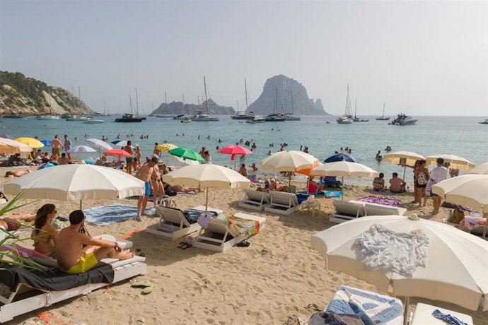 Varias personas en la playa de Cala d'Hort, a 11 de julio de 2023, en Ibiza, Islas Baleares (España).  