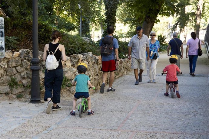 Una persona junto varios niños en el parque de El Retiro