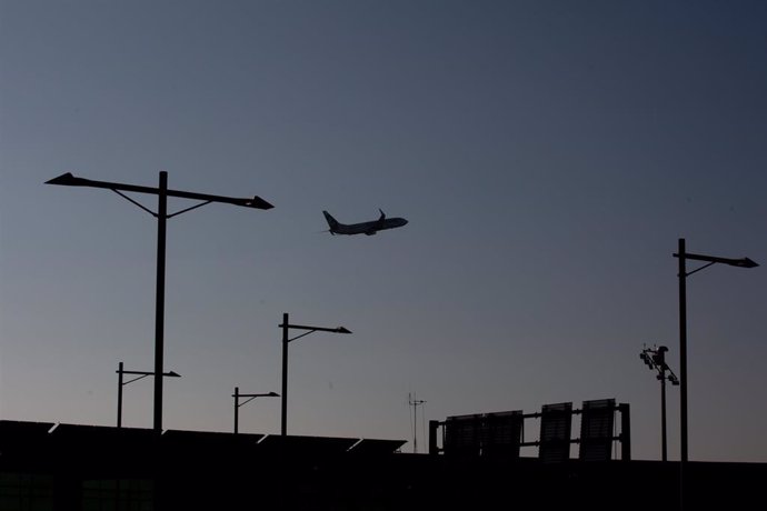 Archivo - Un avión sobrevuela el Aeropuerto de Barcelona-El Prat.