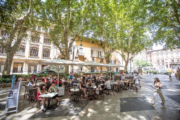 Varias personas en la terraza de un bar, a 11 de julio de 2023, en Palma de Mallorca, Mallorca, Baleares (España). La Agencia Estatal de Meteorología (Aemet) ha activado la alerta naranja en Baleares por una masa de aire cálido de origen africano que de