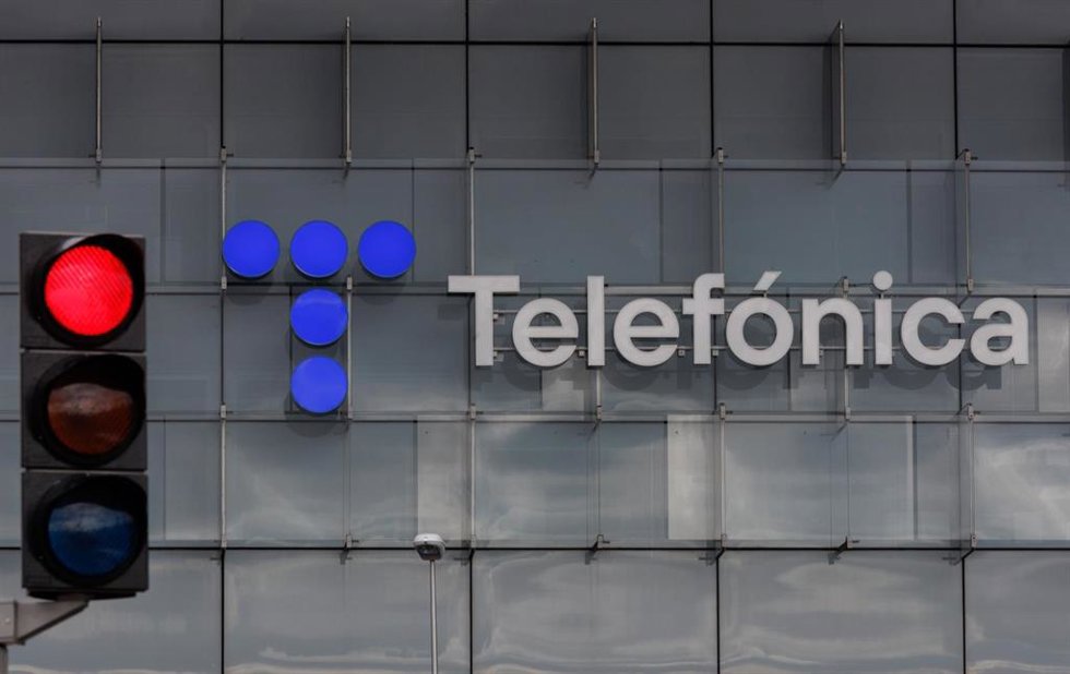 Archivo - Un semáforo en rojo frente a la fachada de la sede de Telefónica