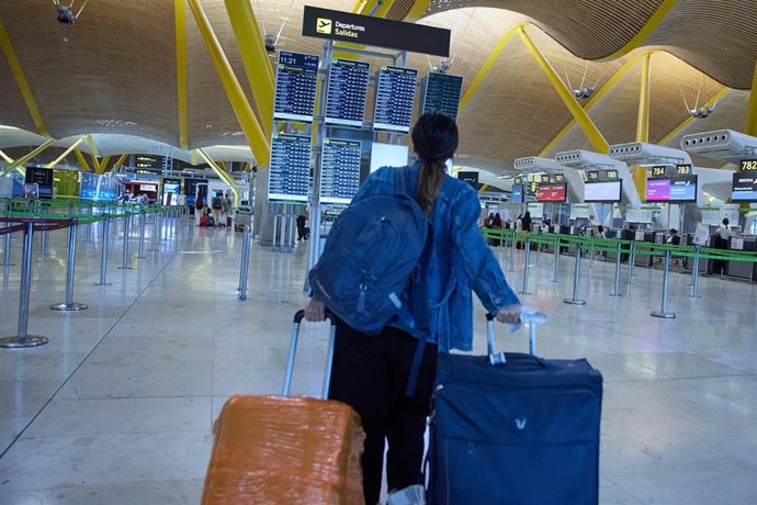 Una pasajera consulta un panel de salidas de vuelos