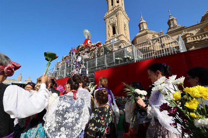 Archivo - Varias personas durante la tradicional ofrenda de flores a la Virgen del Pilar, en Zaragoza.