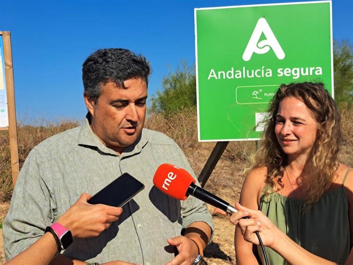 El delegado de la Junta de Andalucía en Huelva, José Manuel Correa, acompañado por la concejal de Turismo del Ayuntamiento de Huelva, Pastora Giménez, en la presentación de la app en la playa del Espigón.