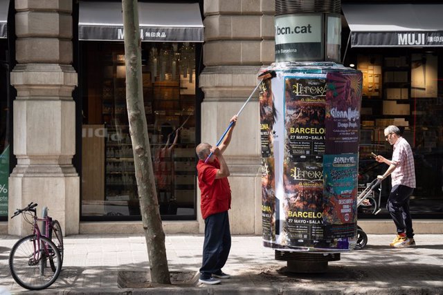 Archivo - Arxivo - Un operari pega cartells, a 10 de maig de 2023, a Barcelona